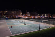 Students play a late night game of tennis at Palmer Field courts outside of the Mosher-Jordan Residence Hall.